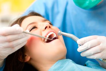 Dentista limpiando dientes de paciente